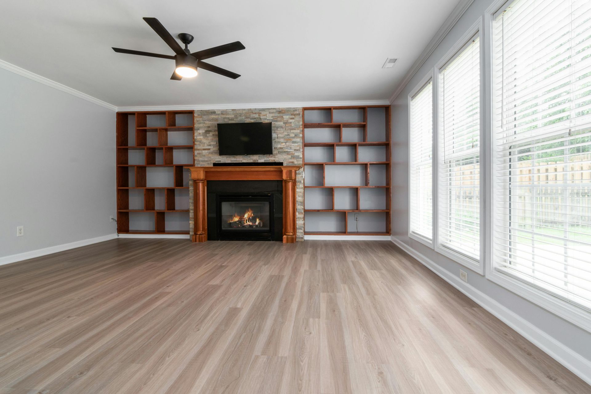 Empty living room with new wood-look vinyl plank flooring and a fireplace